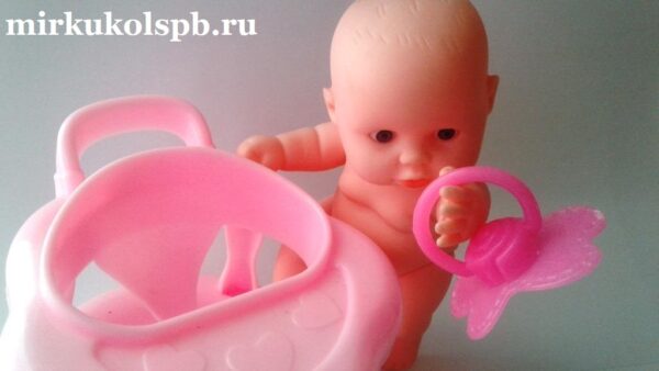 Маленький пупс младенец за розовым столом